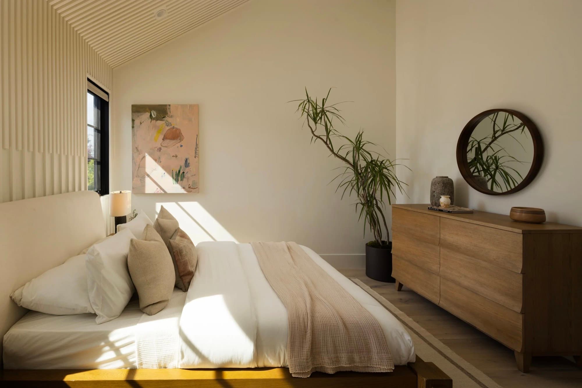 A contemporary painting placed above a bed in a private residence